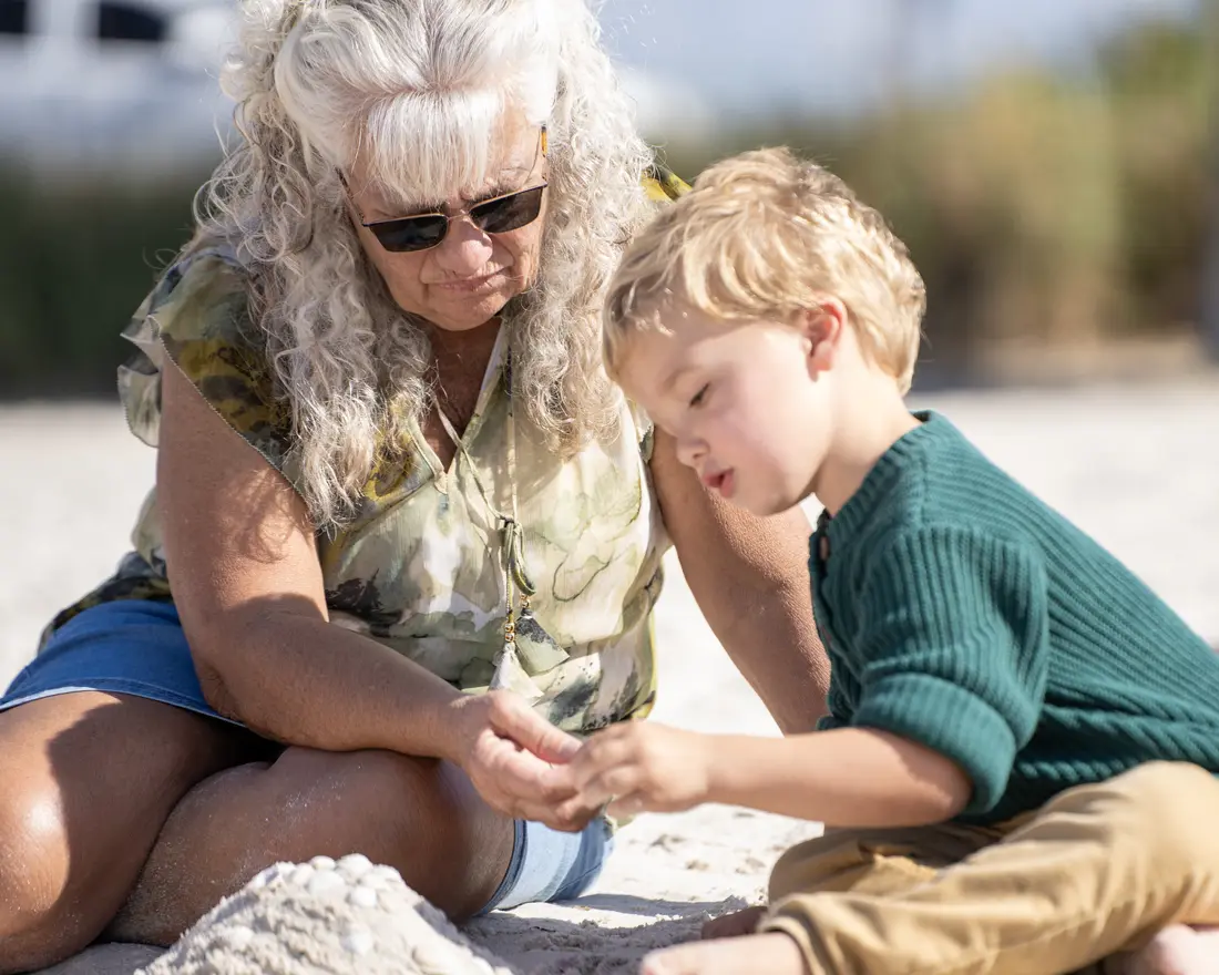 Grandmother on the beach with her grandchild