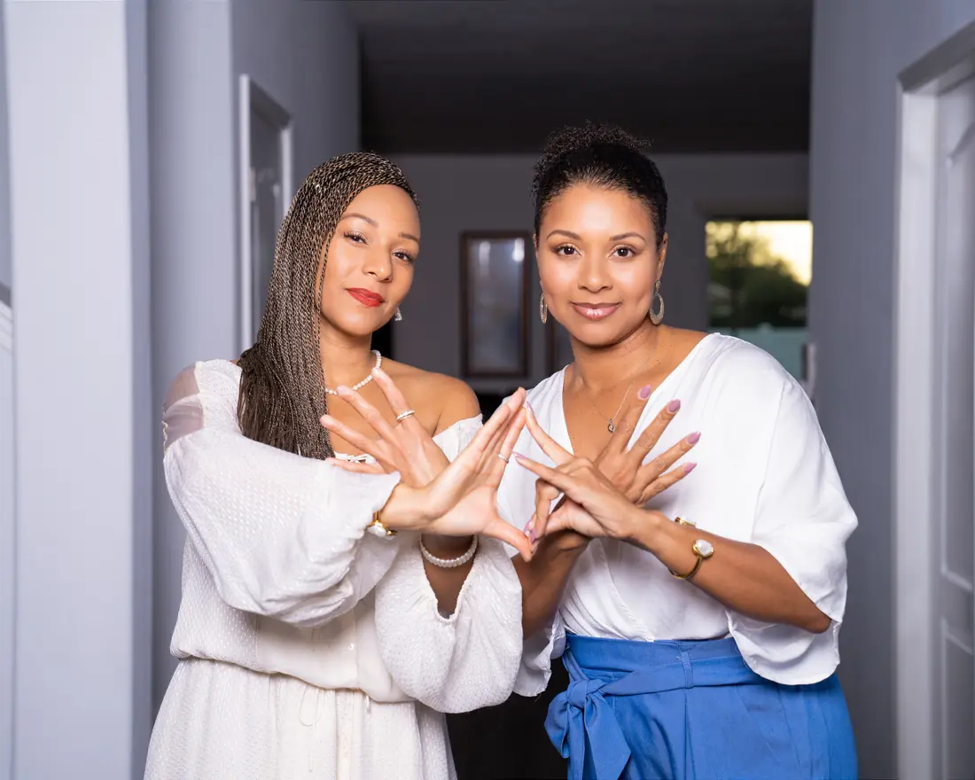 Two sisters posing together indoors